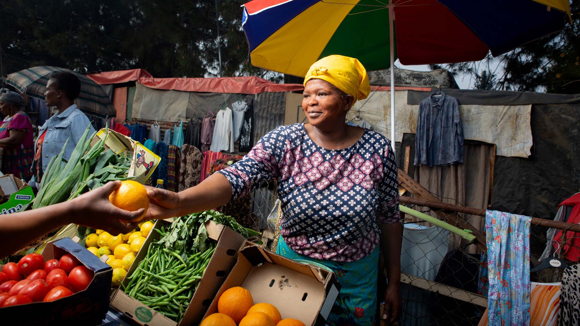 lady selling an orange at informal trade market