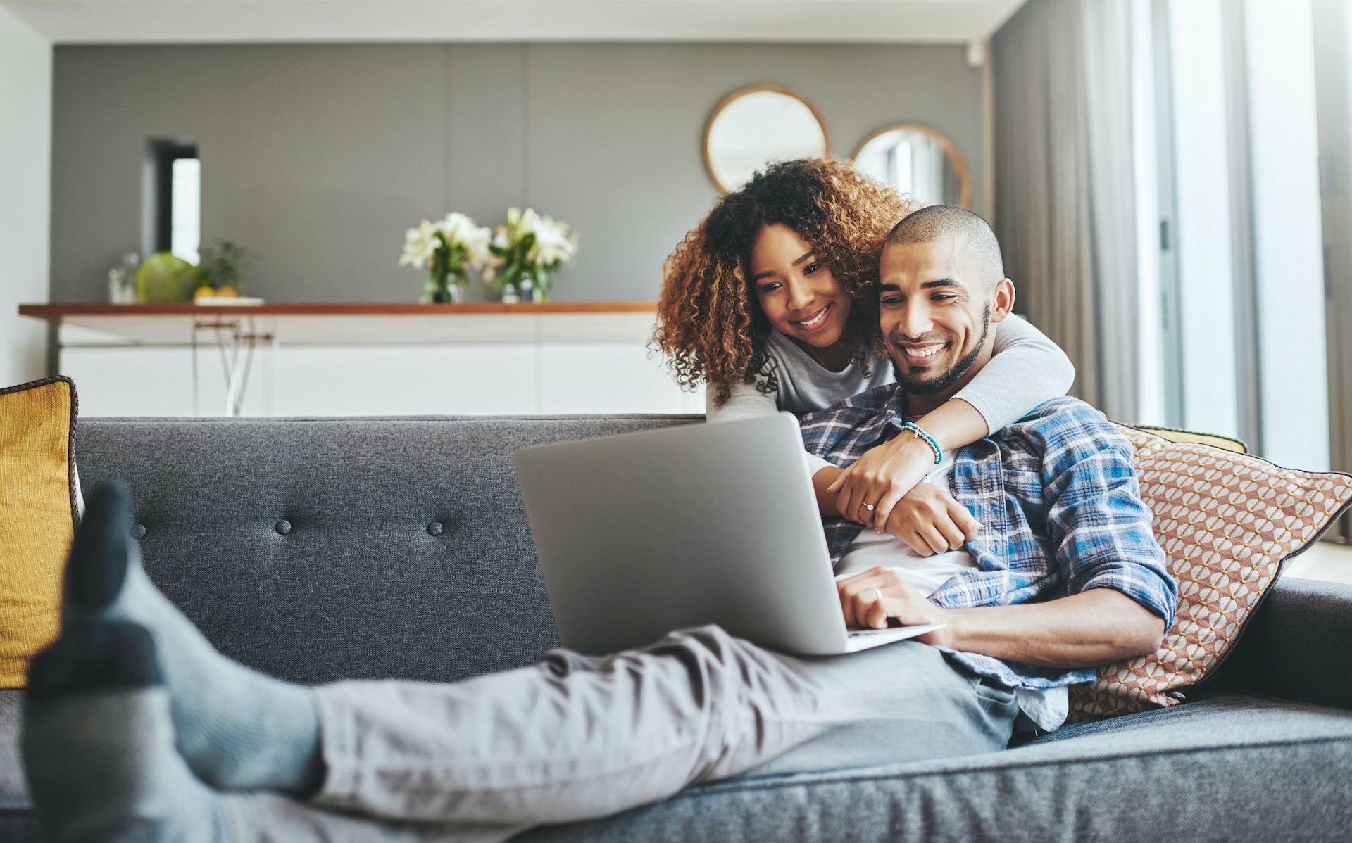 couple on the couch browsing loan offers online
